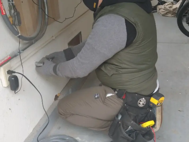 Electrician performing outlet wiring in a North Kensington garage